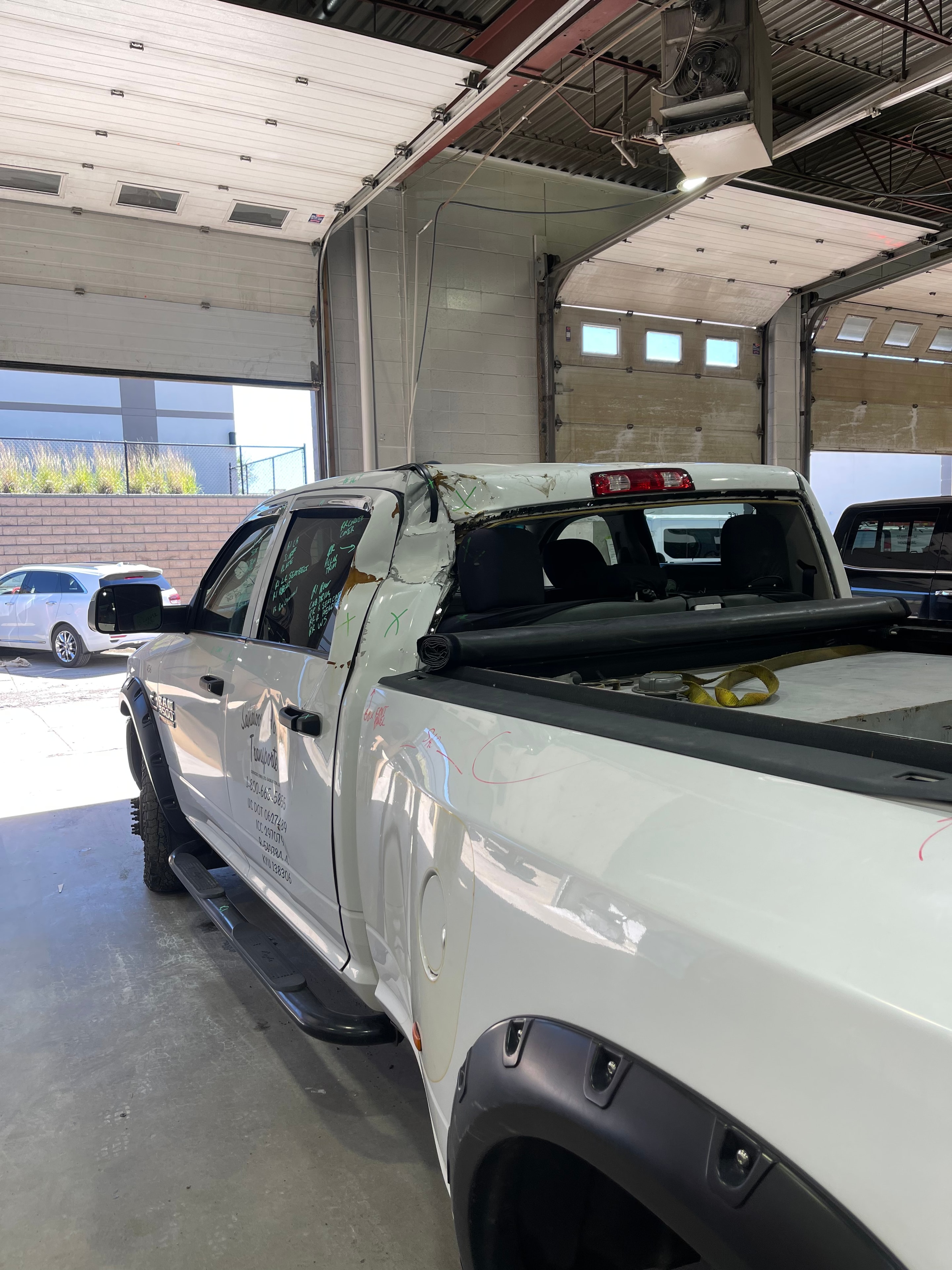 Damaged white vehicle before collision repair in the MACART workshop